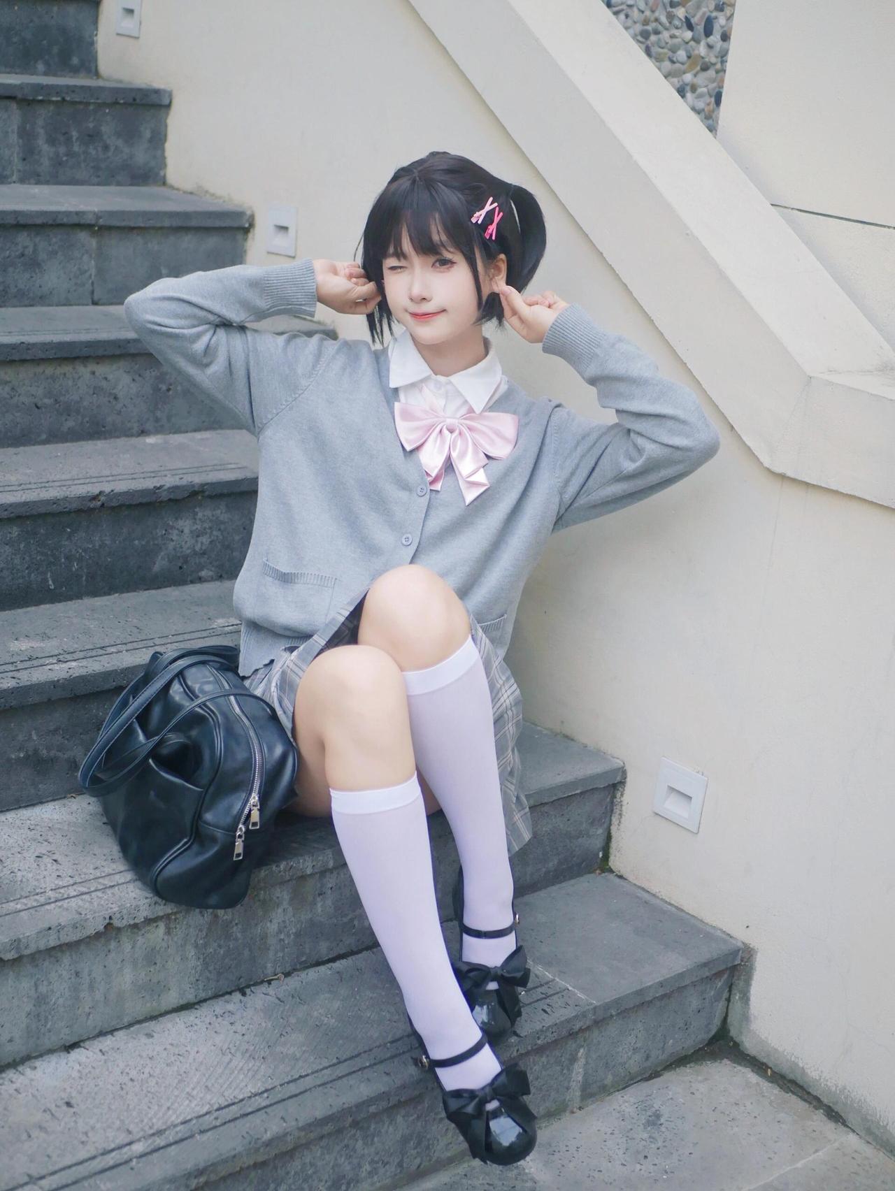 粉衣少女倚石阶，笑语盈盈。