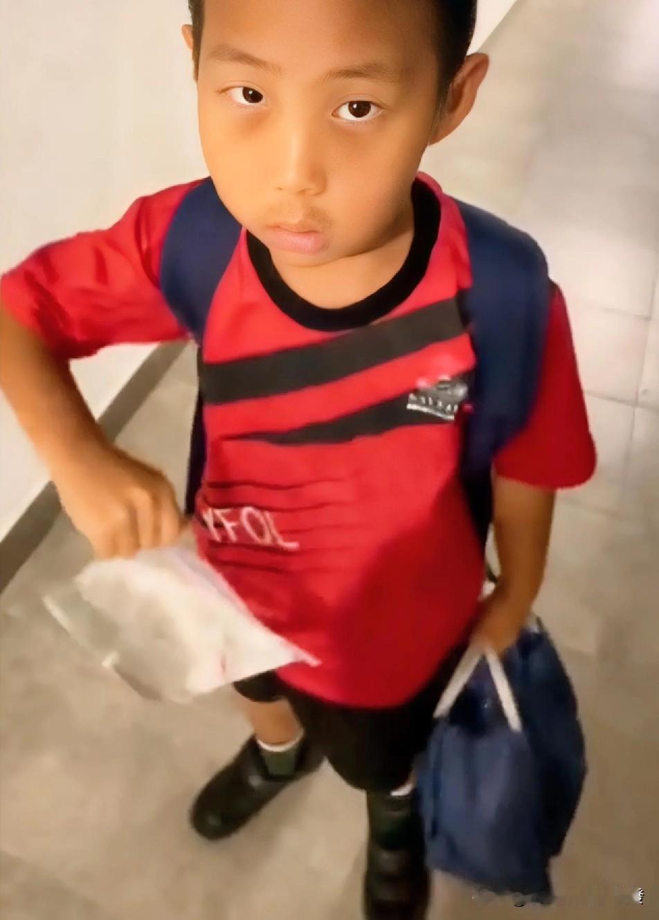 小男孩背着书包准备去上学，临走时爸爸递给他一个带密封条的塑料袋，而里面装了大半袋