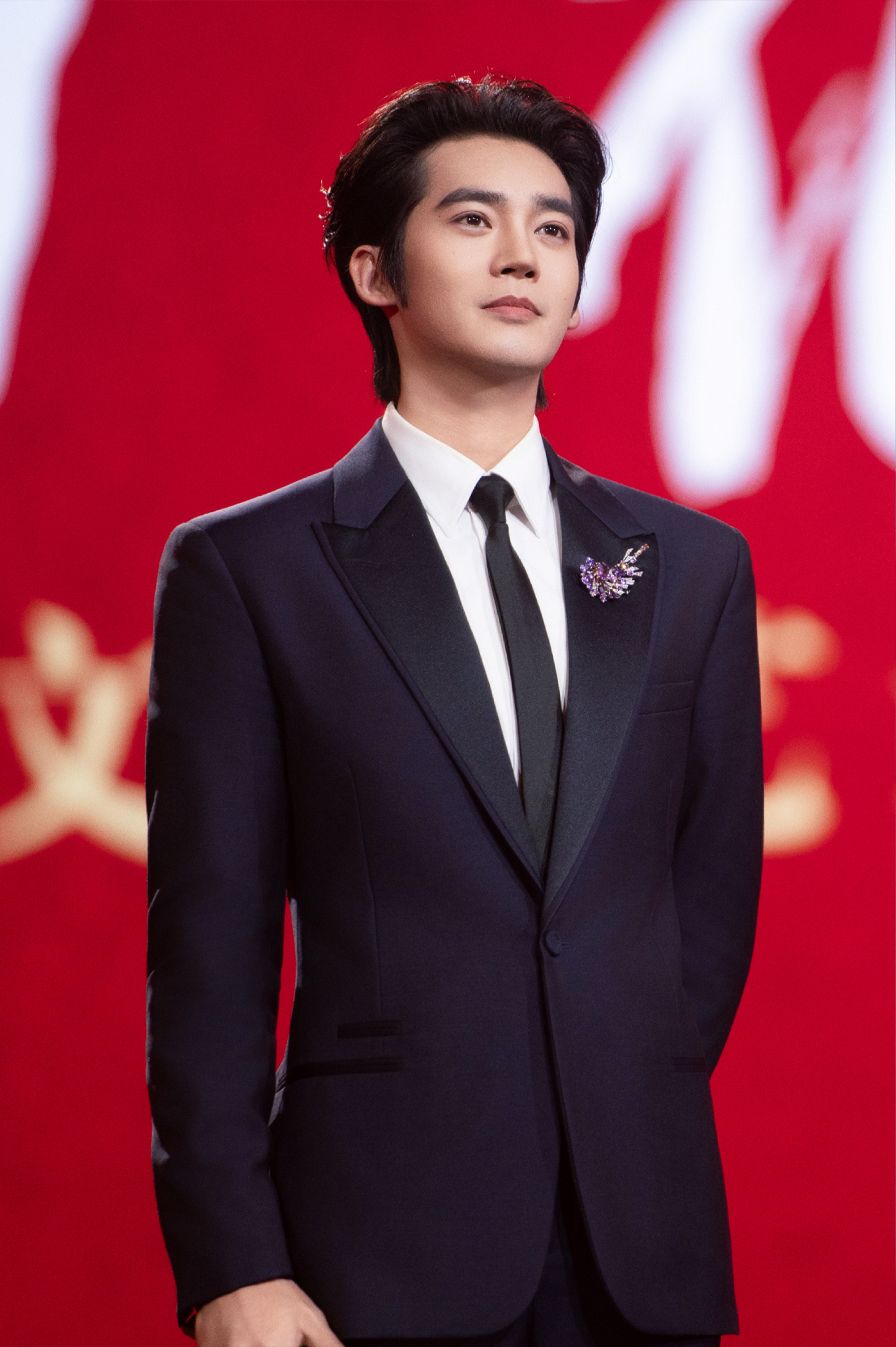 于适佩戴CHAUMET天穹皓境高定珠宝套系凌空圣光主题胸针，笔挺西装。出任百花