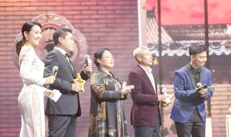 这张照片中，我只认出了胖瘦合度的陈宝国，一头银发的刘佩琦，中间那位鲜衣盛装、戴着