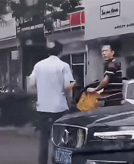 两男子在街头切磋武艺。不得不说,衬衫男这摇闪动作还挺像那么回事的,竟然还成功躲过