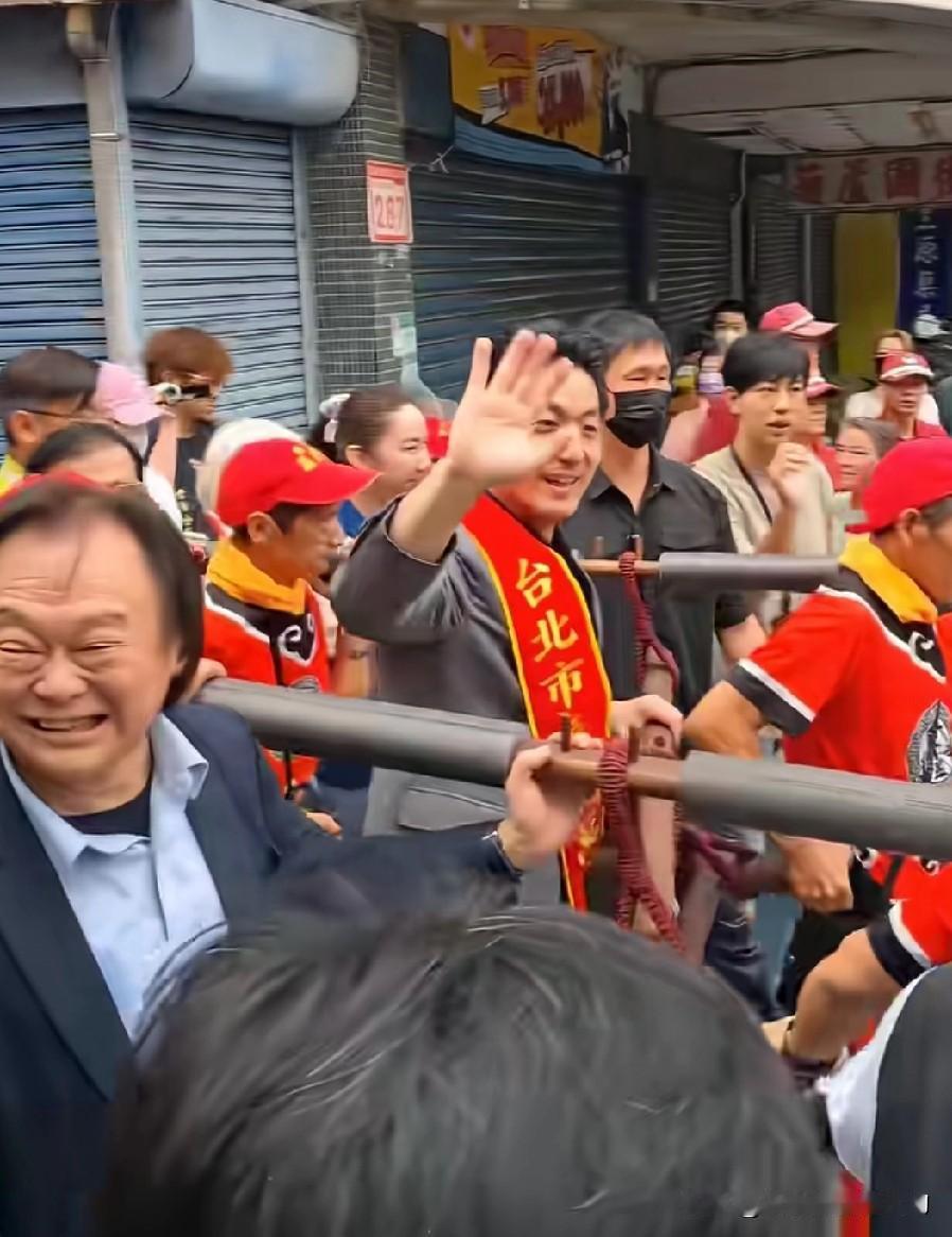 王世坚高兴地为蒋万安扶着轿杆，不停地给周围的群众挥手致意。看来王世坚并不讨厌