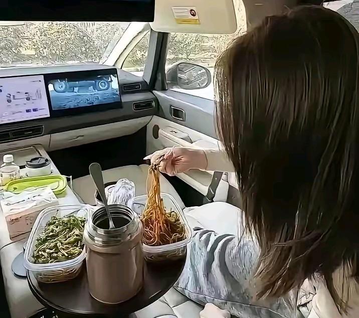 小姐姐在自己的新能源车上就餐，她说让开油车的人羡慕一下，我有点想不通，我们这些坚