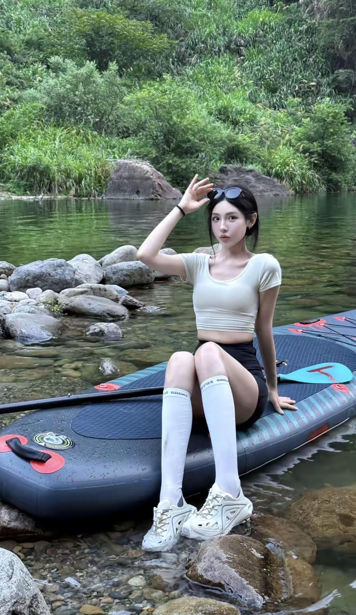 她划着桨板，墨镜卡在头顶，假装是丛林探险家。突然脚下一滑，整个人栽进水里，溅起的
