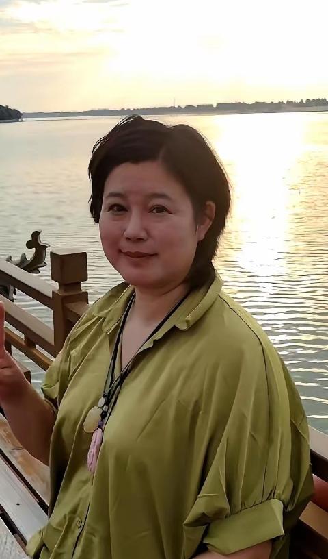 要是没人提醒，打死我也不敢信。眼前这个眯着眼睛、双下巴若隐若现的短发大姐，竟然是