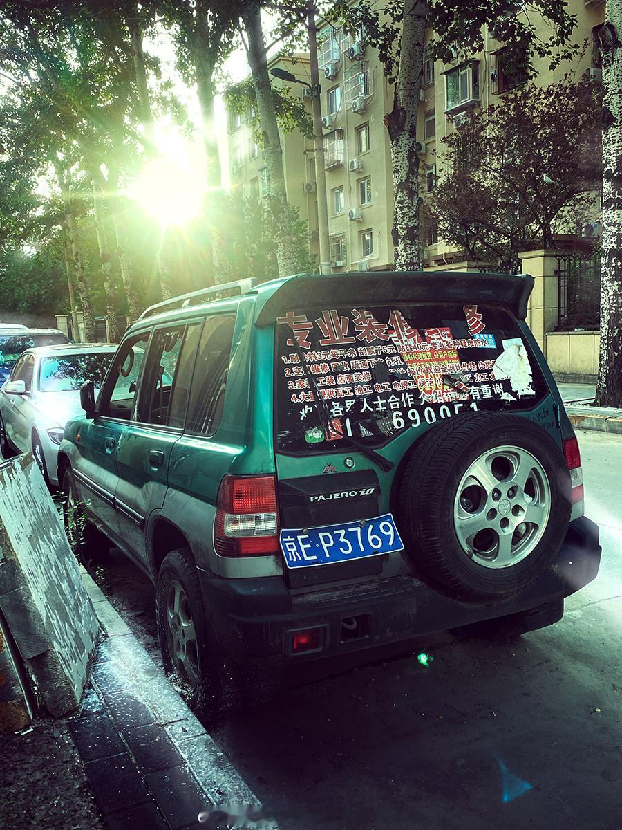 一辆看似被遗弃在路边的帕杰罗io五门，一侧玻璃没了，车内堆了建筑垃圾。不能很确定