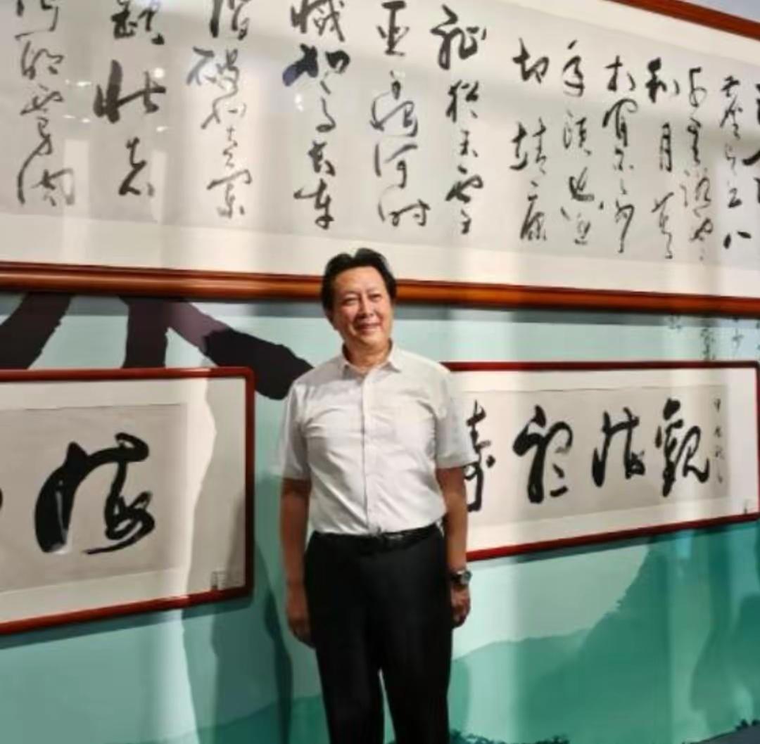 刷到唐国强书法展的现场图，他站在自己那幅草书《满江红》长卷前，盯着字凝神端详半天