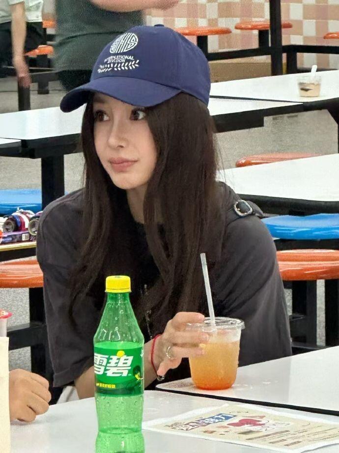 杨颖现身儿子小海绵的校园义卖会她身穿黑色T恤搭配白色裤子和鸭舌帽，清爽又低调