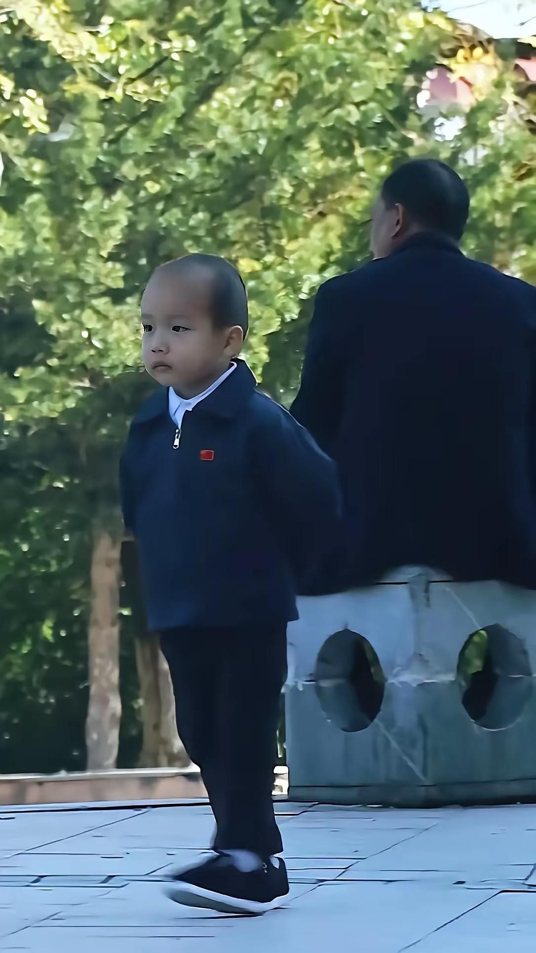 这娃娃领导气质拿捏的，小短腿迈得又稳又快，走路带风，小夹克衫一穿，小手背在身后，