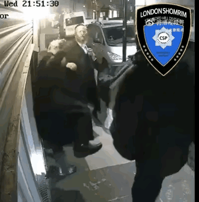 4月15日21点，英国伦敦，2名犹太拉比在街头卷帘门前，1人在打电话，他说“巴