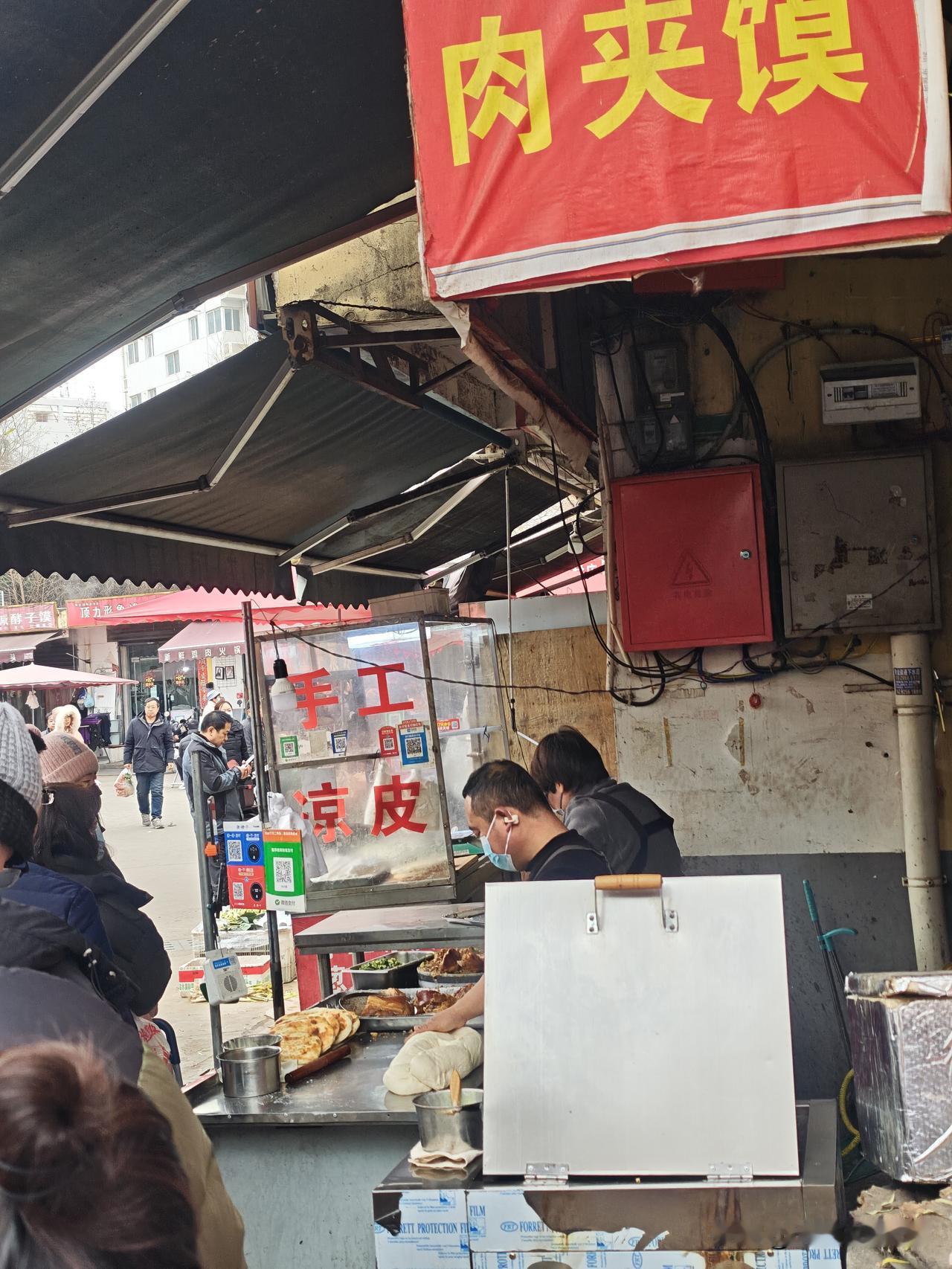 今天早上没事去西航花园菜市场逛逛，发现一家小店卖肉夹馍的竟然排队。我也就跟着排队
