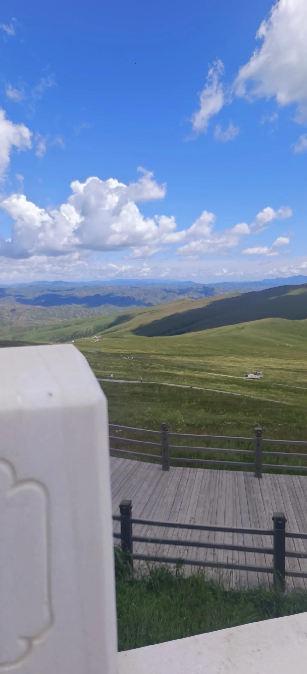 用一张图表示好看的云内蒙古青坤山景区，蓝天白云，景色迷人，敖包壮美，绿草青青，小