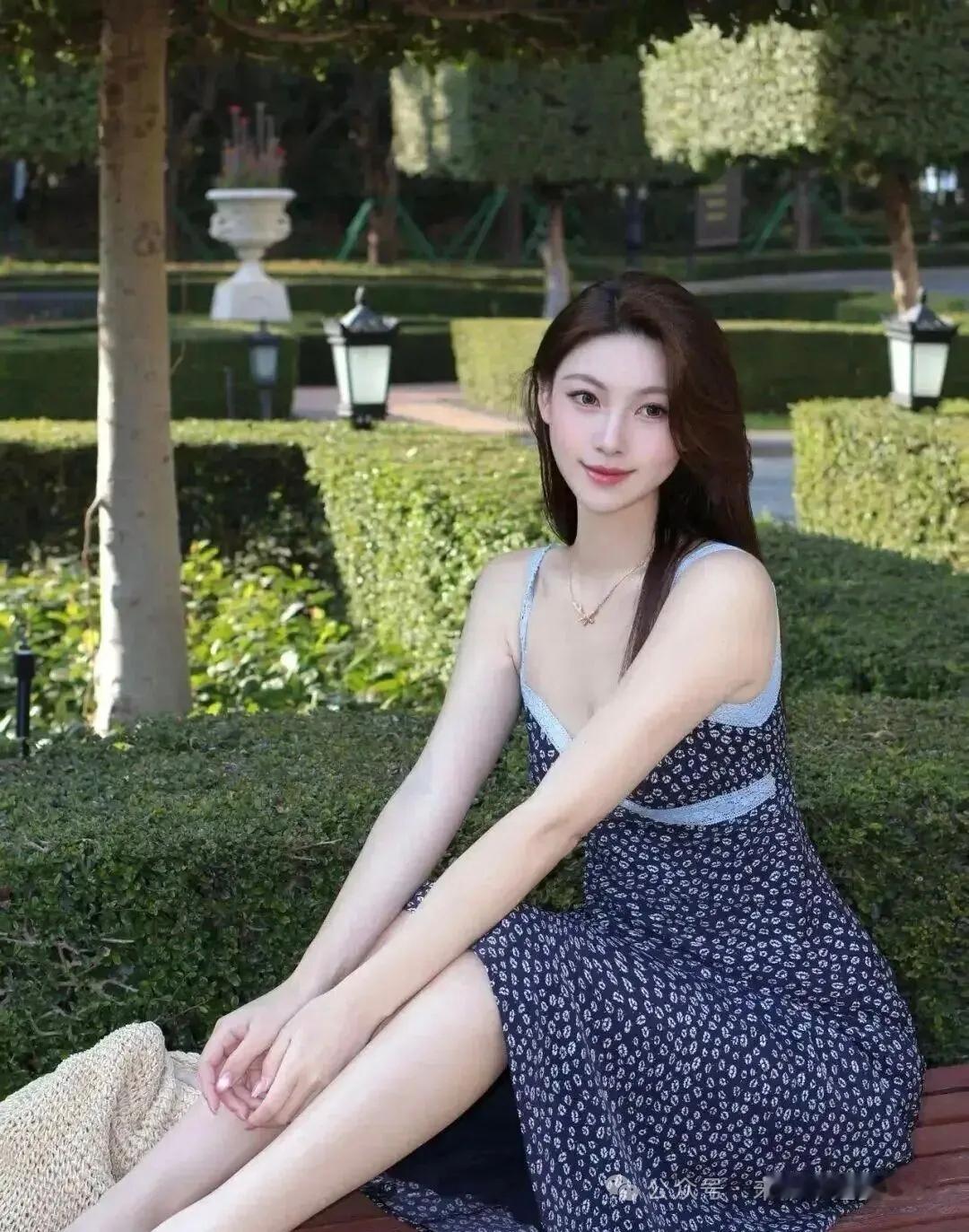夏日午后，公园的绿意像一幅天然画卷。一位少女轻坐在长椅上，笑靥如花，这画面简直美