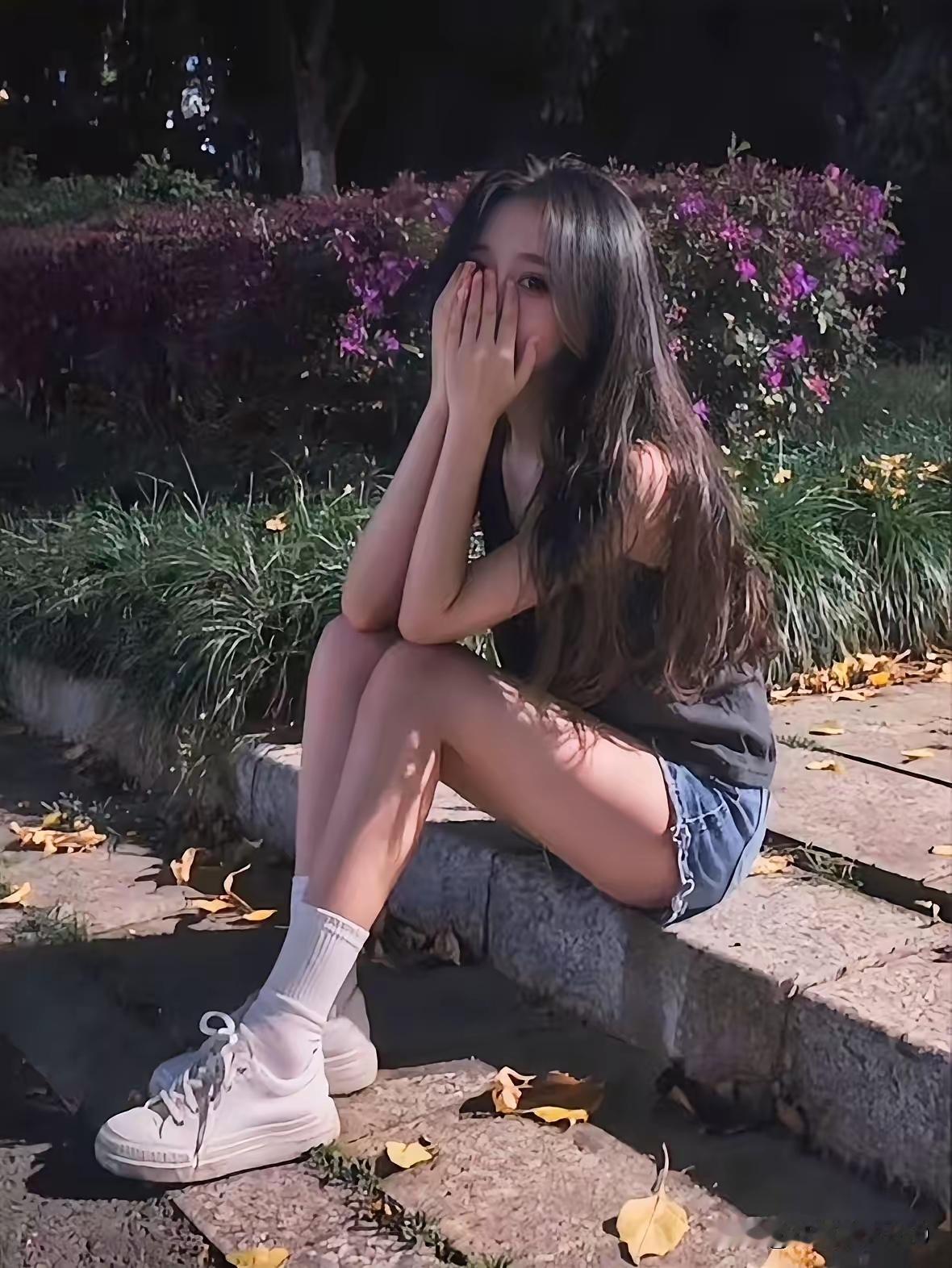 秋日午后，少女倚石而坐，手掩面颊，静享阳光与花香。