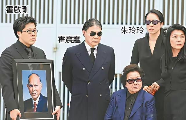 这是红顶商人霍英东先生葬礼上的家族合影，众人皆着肃穆黑衣，神情悲戚凝重。长子霍
