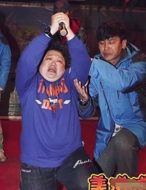 歌唱家韩红在参与公益赈灾义演的现场抓拍：韩红双膝弯曲、双手高举握紧麦克风，情绪