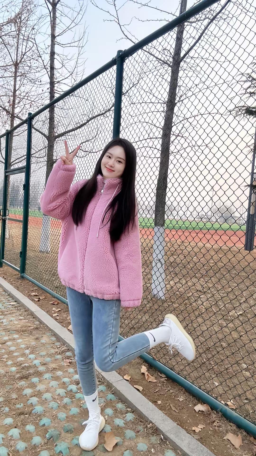 粉衣少女立绿荫，笑语盈盈意自闲。