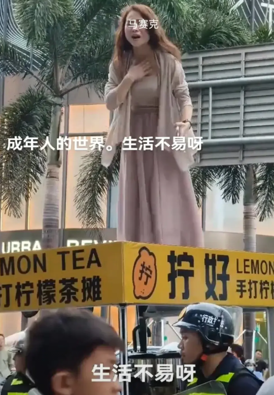 近日，深圳龙华街头，一位年轻时尚的女子爬上自家的手打柠檬茶摊上，悲愤地大喊大叫，