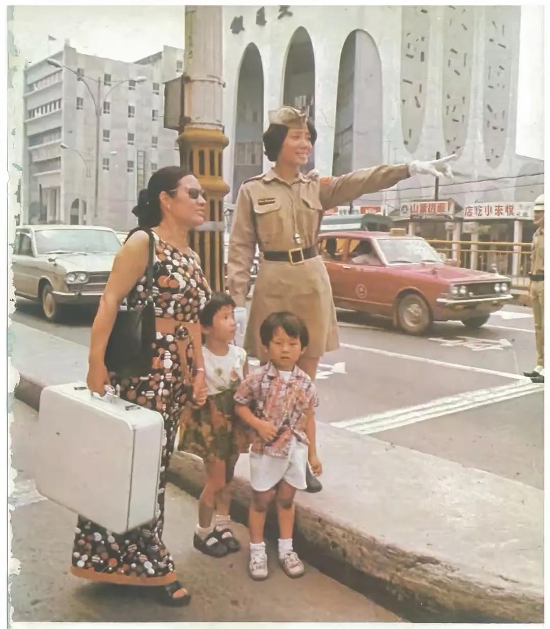 图中是1962年的香港，一位女警察在为游客指路，女警察的着装和现在的黑色警服不一