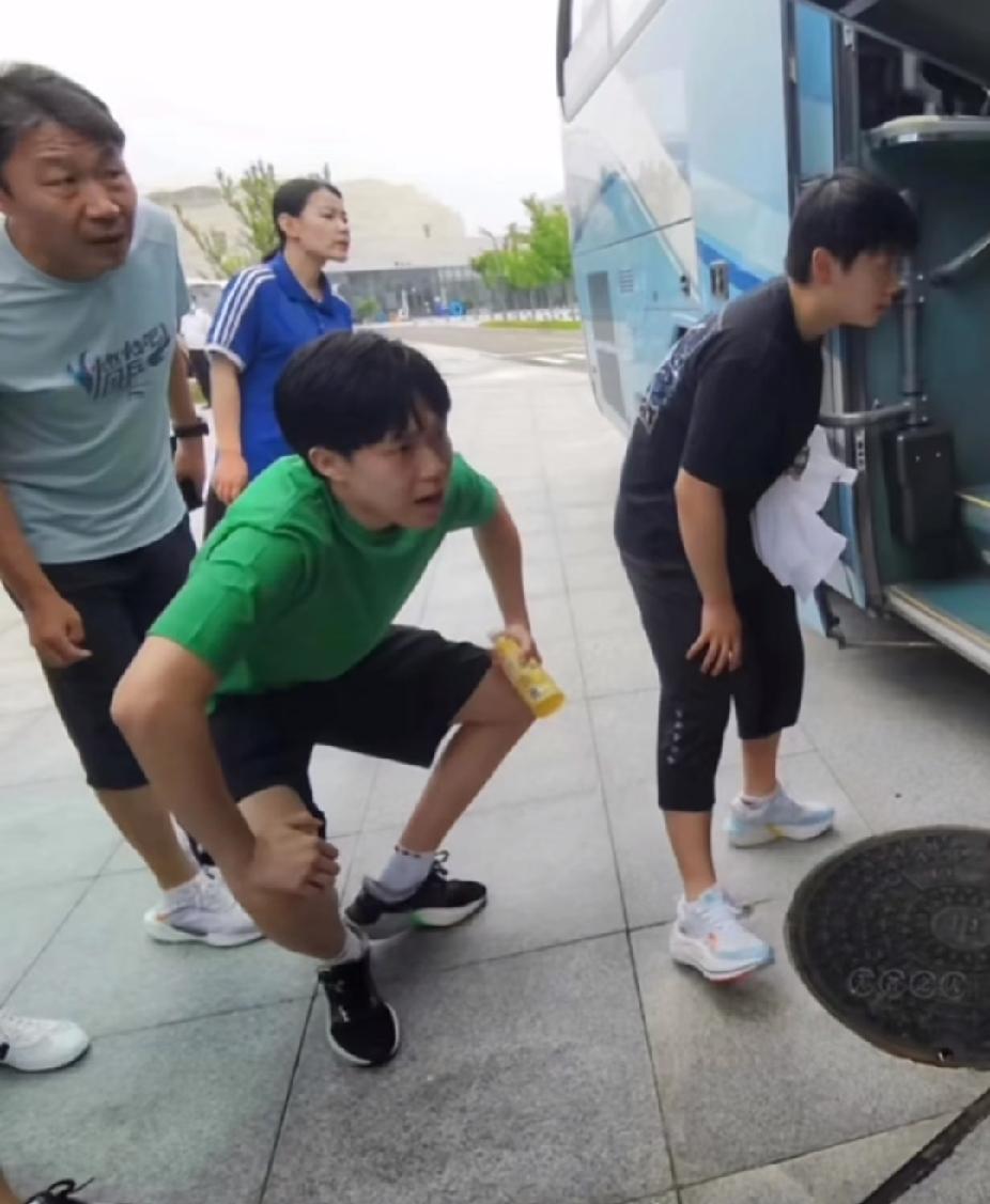 不知道是谁随手抓拍的有趣一幕😂王楚钦半蹲着，莎莎也俯身站在大巴车旁，两个人一