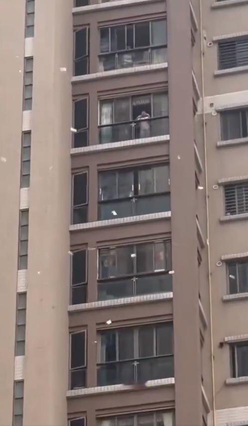 汕头高楼女子往窗外撒大量港币！4月14日，广东汕头龙湖区合信·星湖城小区，一名女