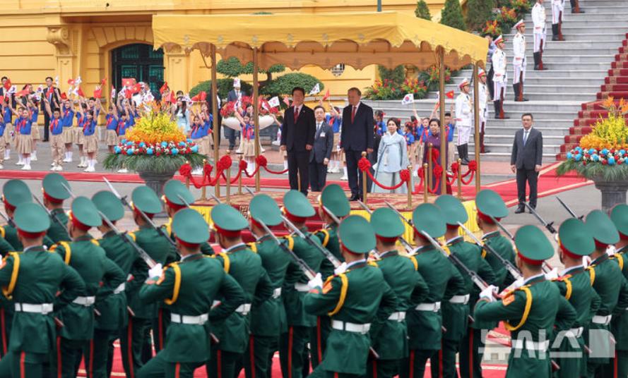 4月22日越南第一夫人与苏林一起接待韩国总统夫妇，一身高贵紫亮相欢迎仪式，彰显端