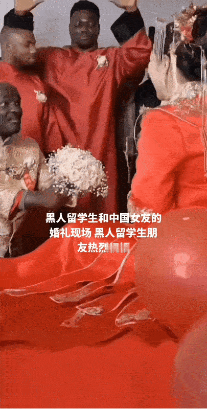 中非婚礼现场。一名黑人新郎跪在床前向他的中国新娘献花表白。而在新郎的身边还可