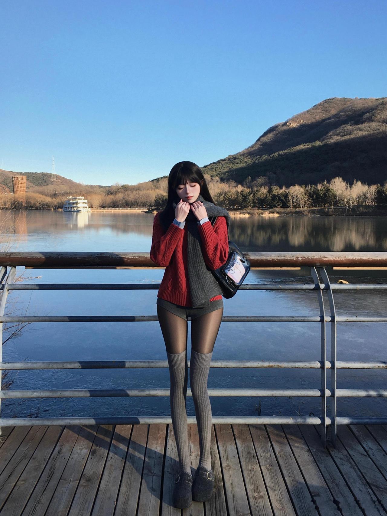 冬日暖阳下，少女倚栏沉思，静享湖畔时光。