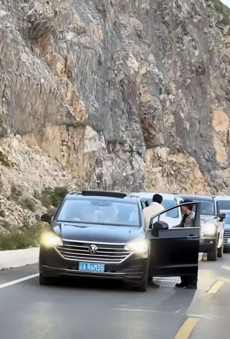 独库公路堵车，黑车明显是故意堵后面的白车。黑车的三四个人轮流下车磨蹭时间，堵着后