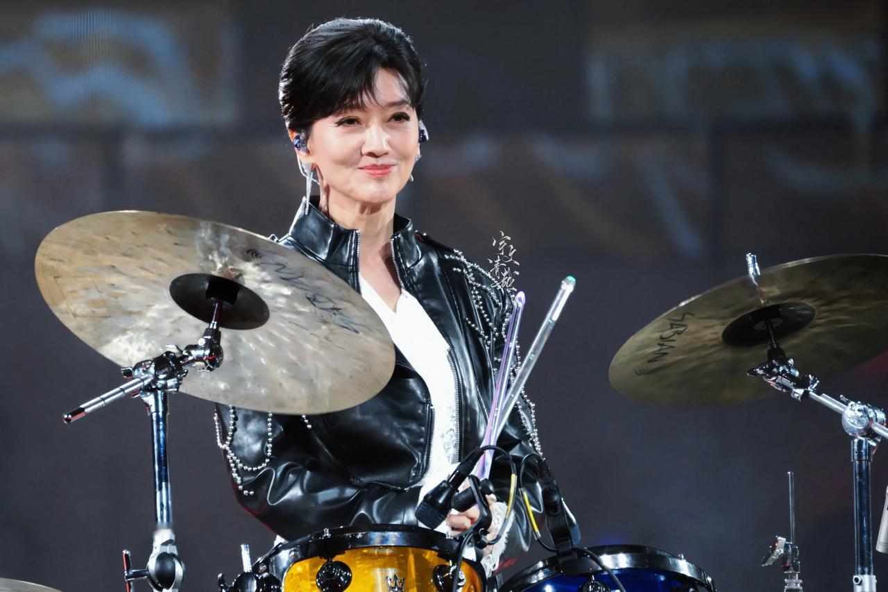 赵雅芝的老公看着舞台上的她，半天没说话，三个儿子也愣在那儿沉默着，一脸不敢相信。