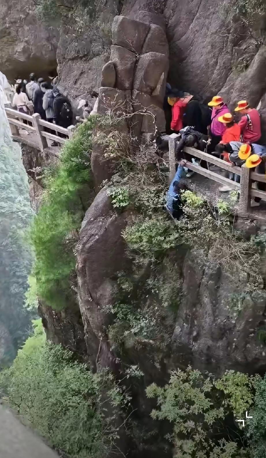 景区里，一名女游客冒死捡充电宝，掉下去了是不是还得讹景区一笔？扔垃圾捡到宝景区