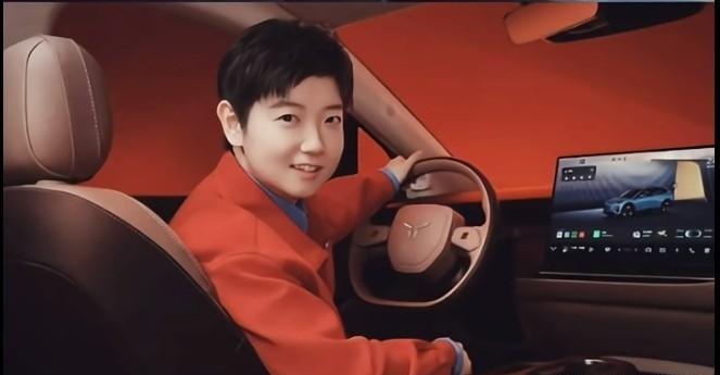 哥姐再次完美配平！莎莎穿着大红色外套，坐在红旗天工的驾驶室里，手握方向盘，笑靥如