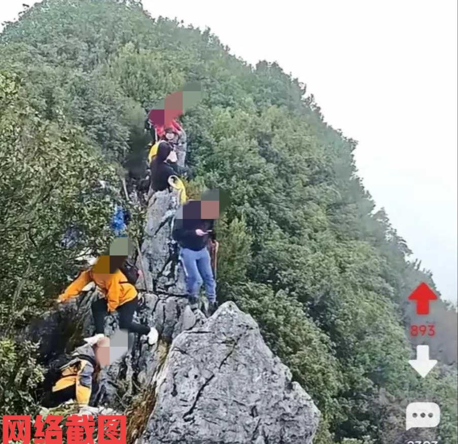 四川广安有男子站立悬崖石壁顶上玩手机。只是让男子没有意识到自己所处的危险环境