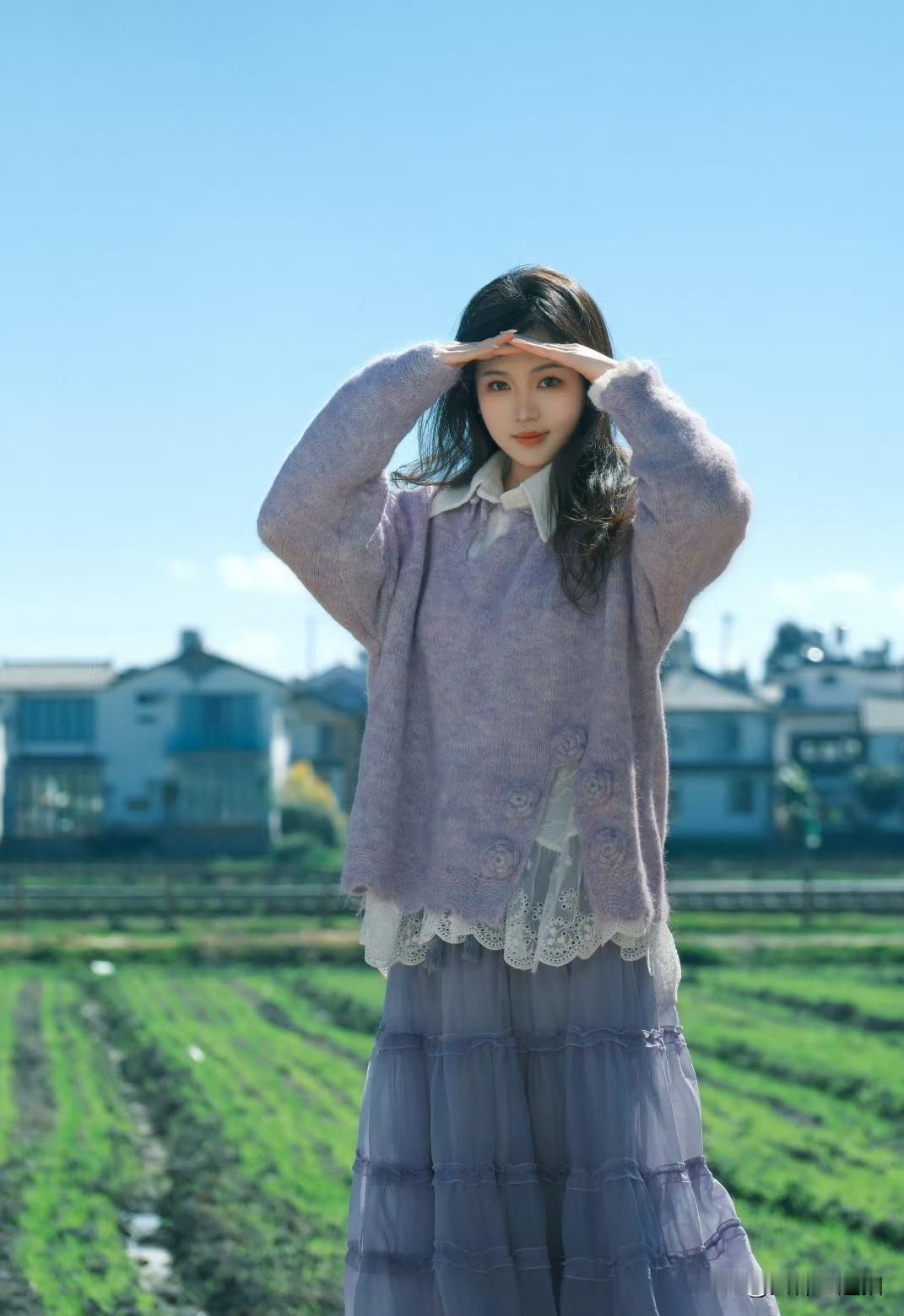 田园少女风，紫色毛衣搭配蕾丝裙，阳光明媚的田野里，少女俏皮地遮挡阳光，笑靥如花。