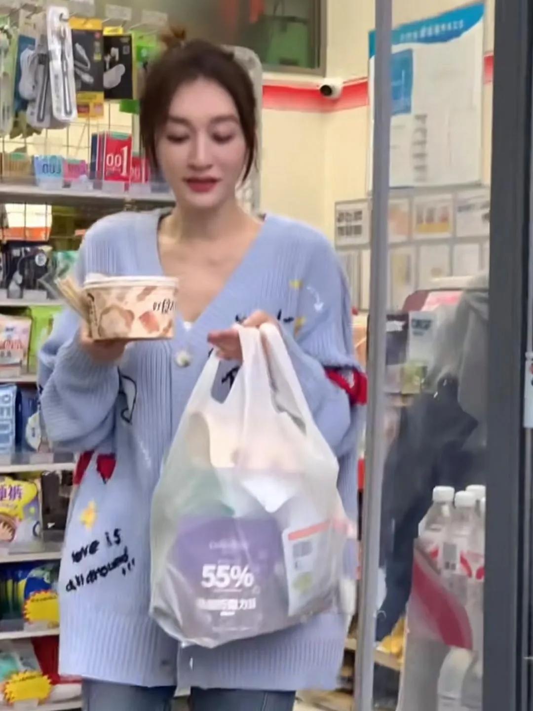 50岁的李小冉出现在长沙一家便利店购物。丸子头，肤白貌美，穿一件长款毛衣，牛仔裤