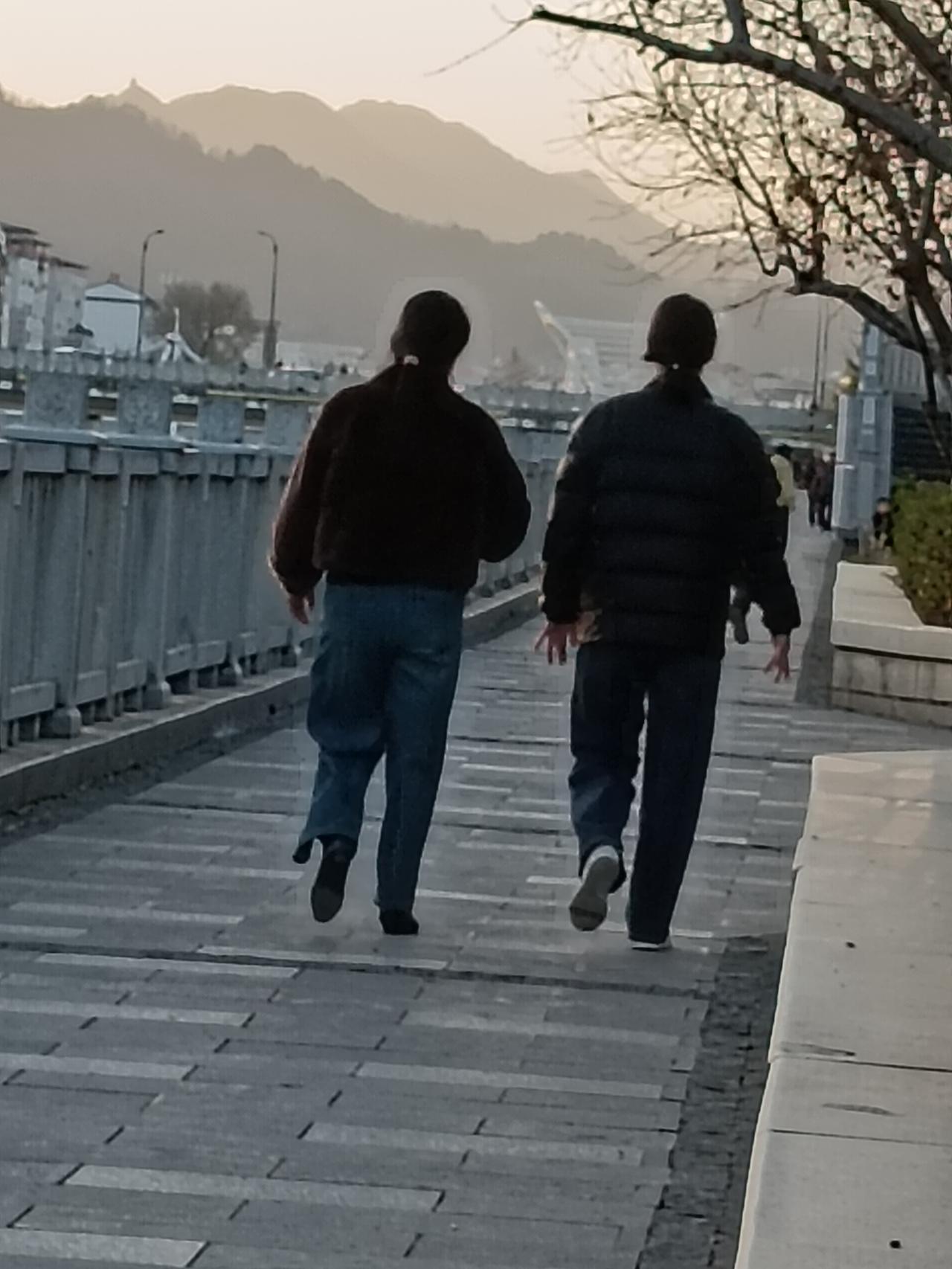 不愧是当过兵的姐妹，瞧瞧这走路的步伐，整齐划一。能看出这照片是在哪儿拍的吗？快