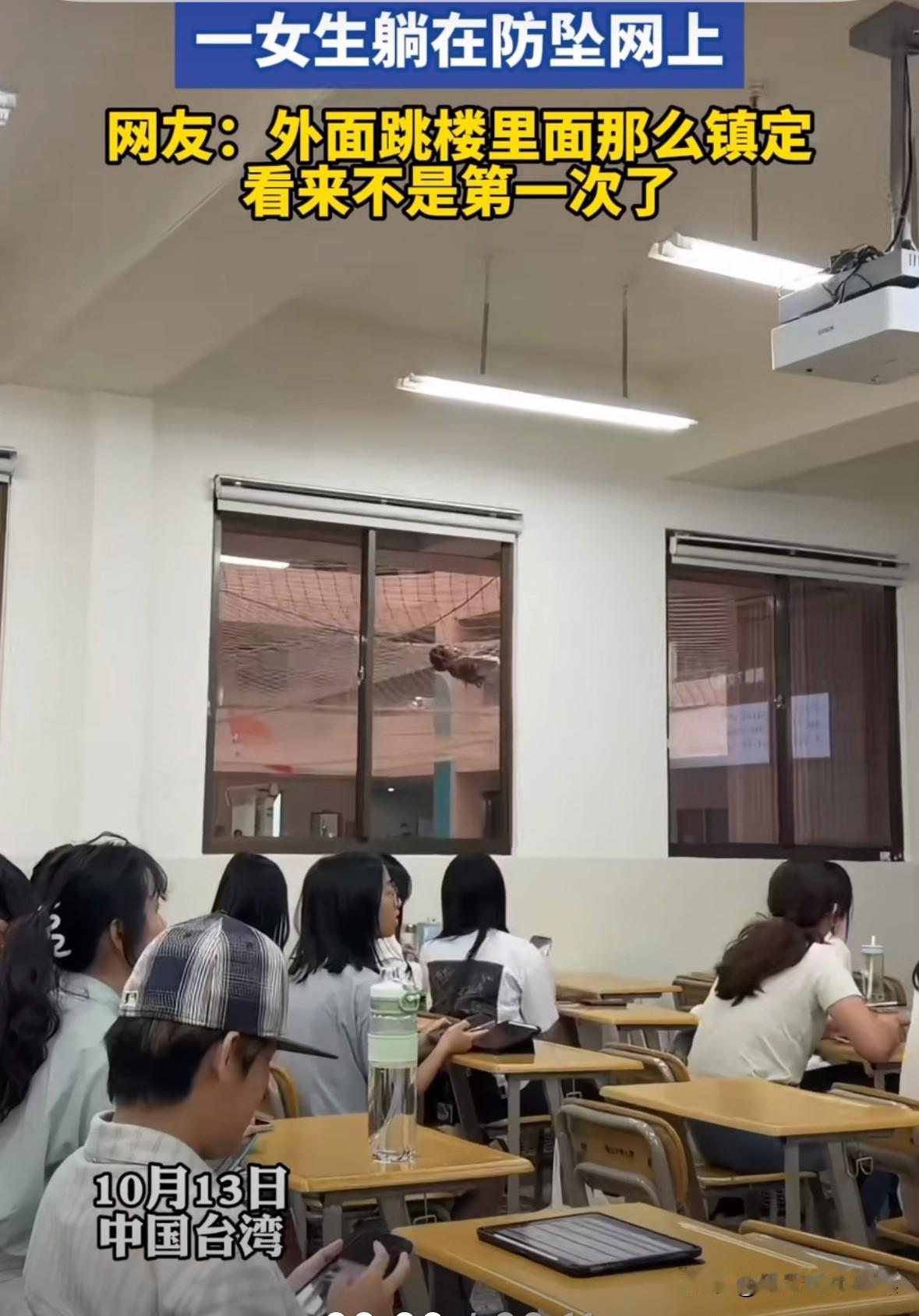 台湾某高校内，一名女学生跳楼掉到了防坠网上，一脸生无可恋！教室里的学生看到后，