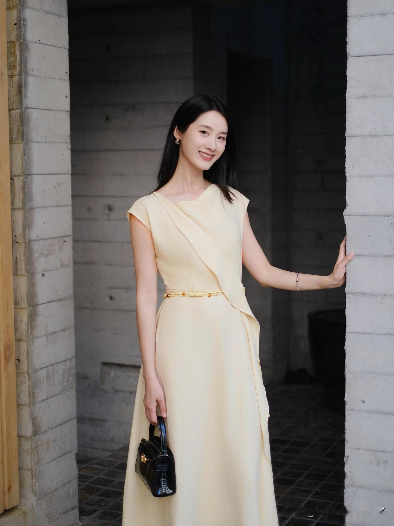 优雅气质，米色连衣裙搭配黑色手提包，完美演绎都市女性风范。