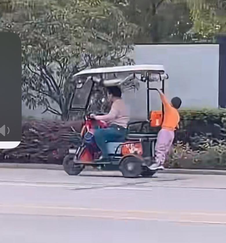 马路上看到的惊险一幕，奶奶骑着三轮电瓶车飞驰，孙子趴在后背玩杂技，就是这样纵容孙