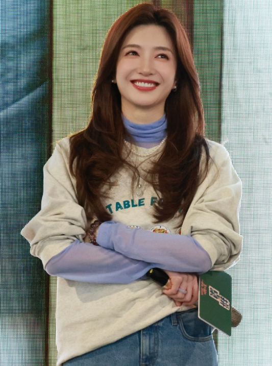 江疏影里面穿蓝色长袖衫外面套着米色的潮流T恤，两件衣服叠穿的效果极为出众。她