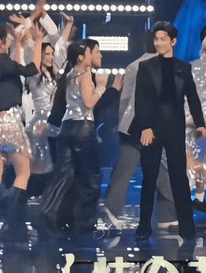 肖战表演完，有个伴舞的姑娘本来只是挥挥手表示告别，结果肖战误以为要击掌，就和她击