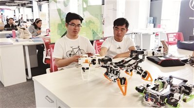 图为张春松(右)和他的变胞机器人.