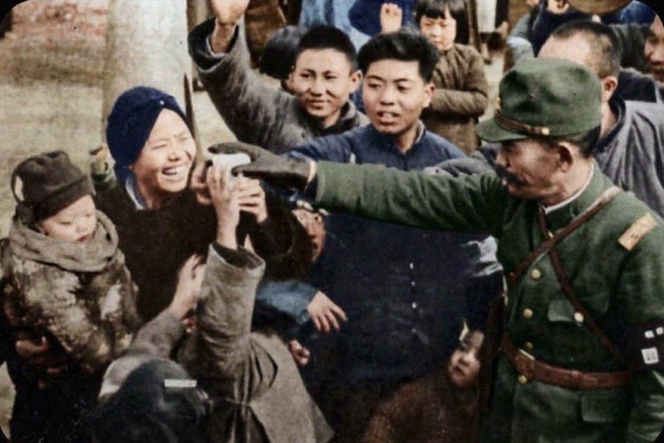 这张照片被标注为“1938年初华北某地”，前排几个国人举手抢东西，表情夸张得近乎