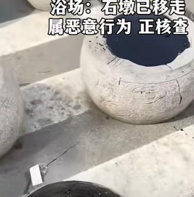 山东日照一处海水浴场门口，网传画面能够看到，浴场门口一排隔离石墩顶部，被人厚厚抹