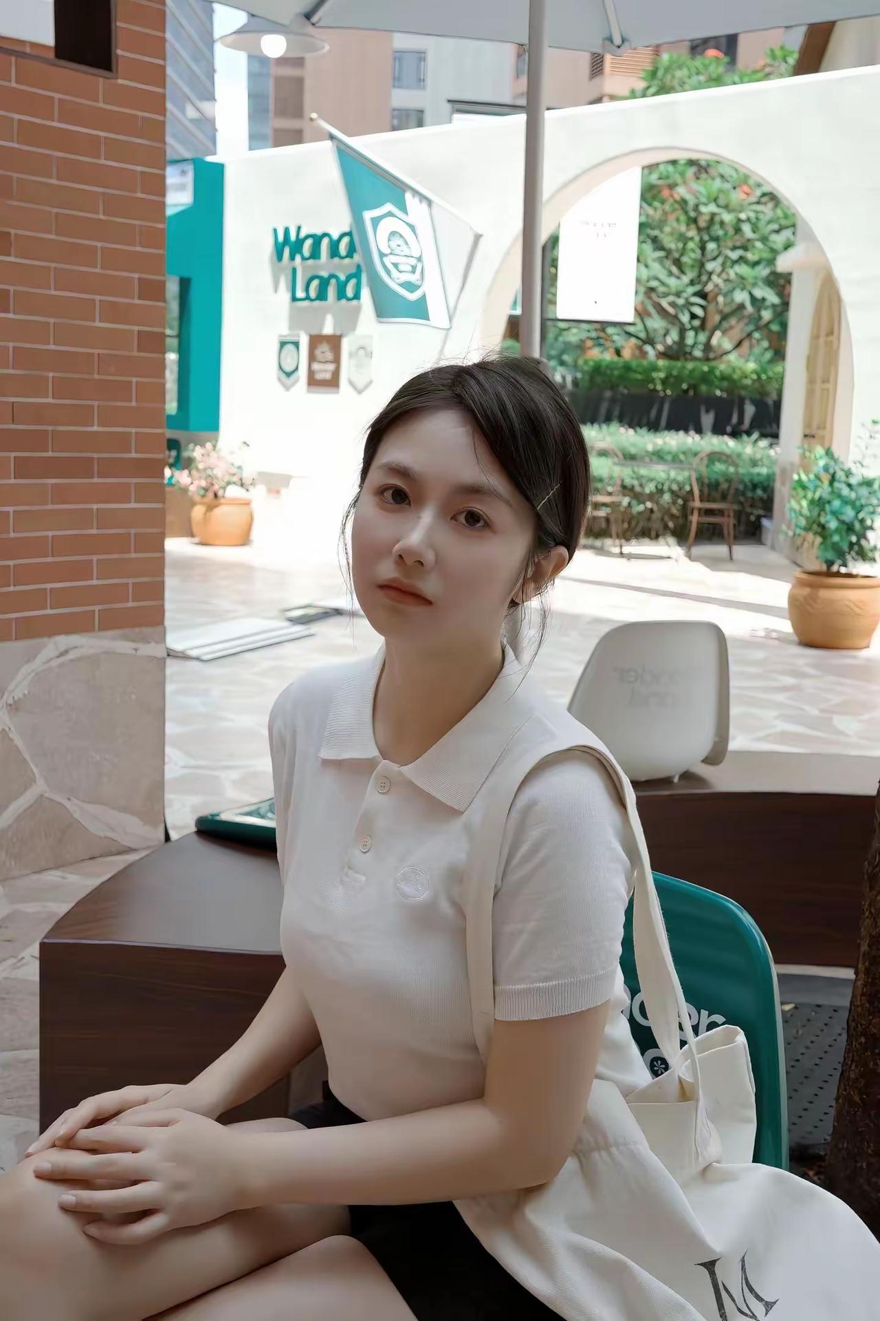 夏日穿搭:白色T恤配黑色短裤。在WandaLand的咖啡馆里，享受悠闲的午后时