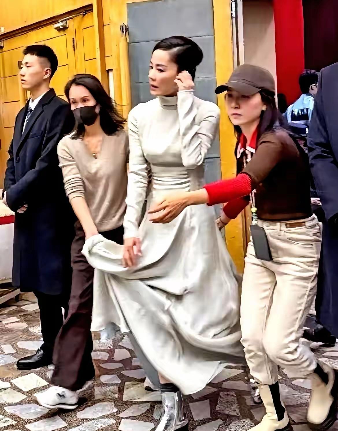 要说王菲这排场可够大的，光提裙子的就两个，可能还有前面开道的，当然也是工作的需要