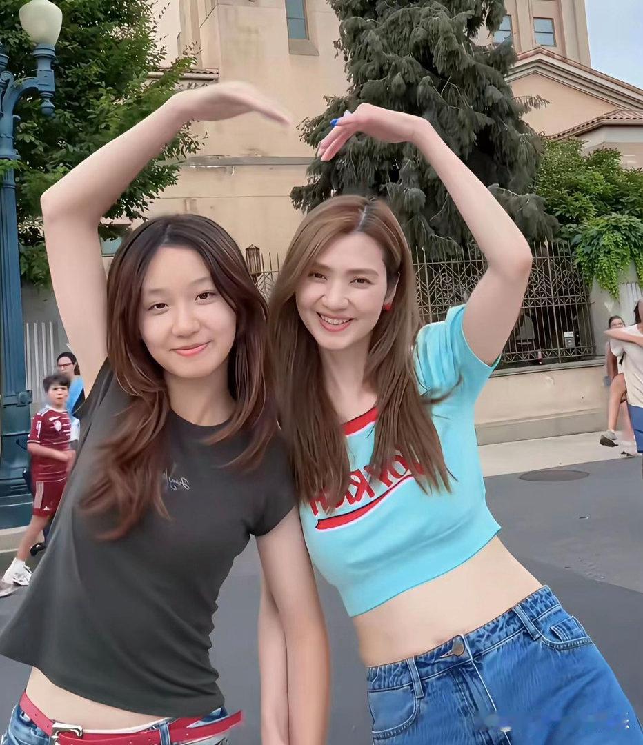 洪欣带女儿出去游玩，54岁的她保养的很好，与12岁的女儿在一起像姐妹。她的基因才