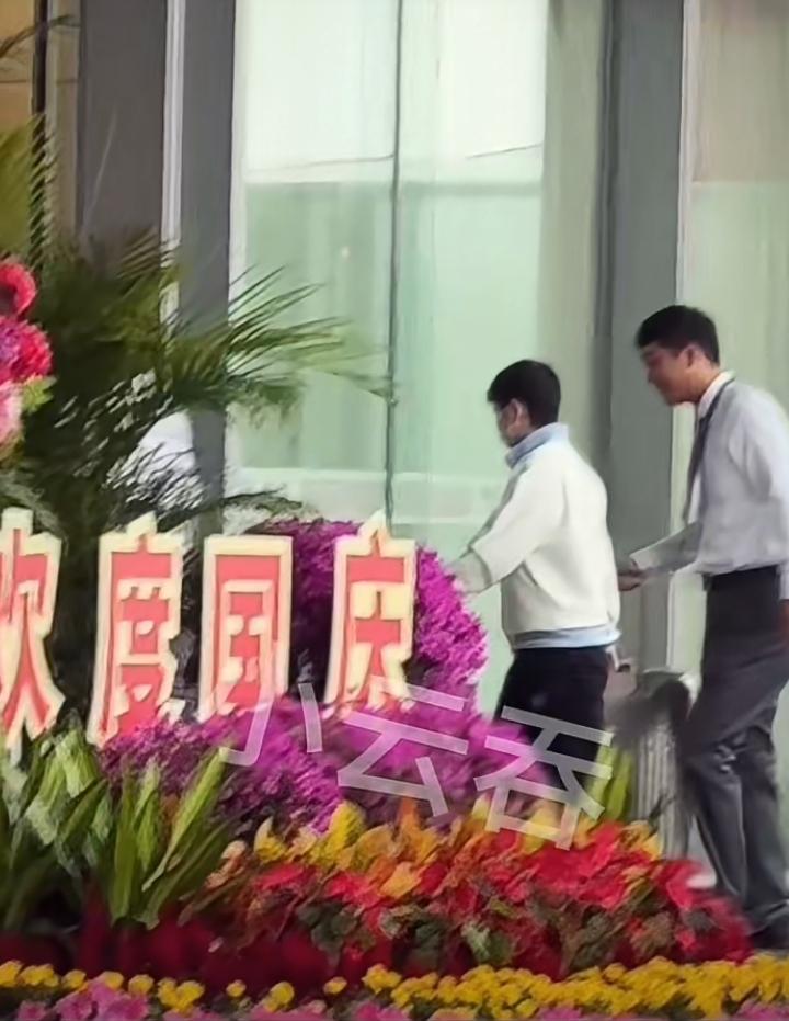 终于见到莎莎了！在两个看起来很稳重的工作人员的保护下，穿着朴素白色外罩、黑色长