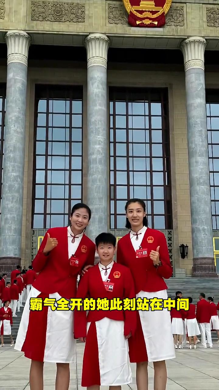 人民大会堂前，乒坛小魔王孙颖莎被两位近两米的女排高个姐姐温柔簇拥。赛场霸气全开的