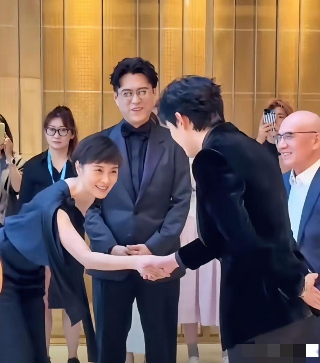 画面中的吴越衣着时尚，短发利落，皓肤如玉，气质清甜，笑靥如花，可是面对晚辈吴磊，